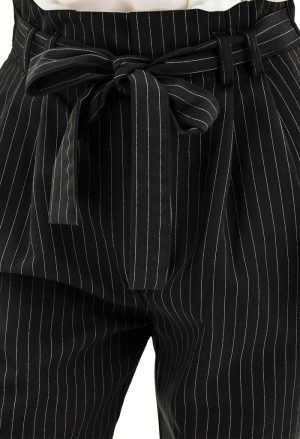 Gestreifte Hose schwarz weiß mit Falten, Taschen und Stoffgürtel.