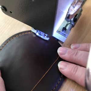 Untersetzer rund braun aus Leder wird genäht. Ohne Logo.