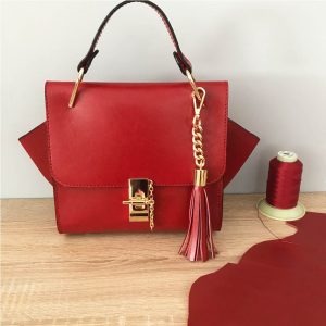 Kleine Ledertasche rot mit Henkel, Drehverschluss mit Kette in Goldoptic, Lederquaste. Nicht zu klein und nicht zu groß.