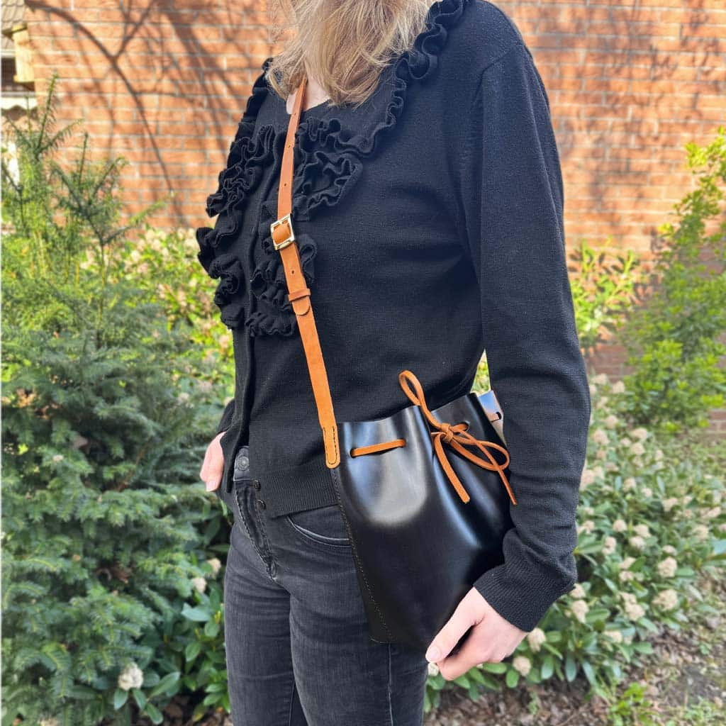 Zweifarbige Leder crossbody und Schultertasche schwarz mit cognacbraunem Riemen und Band. Mittelgroße Bucket bag mit einem längenverstellbaren, praktischen Riemen. Elegante. leichte Damen Ledertasche handgefertigt, geeignet für jeden Tag.