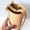 Helle kleine Ledertasche in beige sand Umhängetasche und Schultertasche. Mini Bucket bag mit rundem Boden. Längenverstellbarer Riemen. Magnetverschluss. Tasche handgefertigt aus genarbtem, glatten Rindleder. Auch in schwarz, braun, rot, weiß, grün usw. zu kaufen.