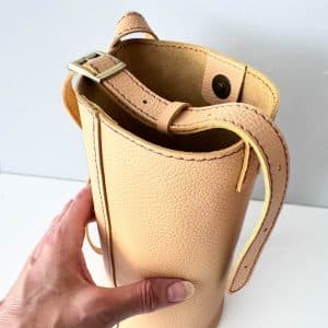 Helle kleine Ledertasche in beige sand Umhängetasche und Schultertasche. Mini Bucket bag mit rundem Boden. Längenverstellbarer Riemen. Magnetverschluss. Tasche handgefertigt aus genarbtem, glatten Rindleder. Auch in schwarz, braun, rot, weiß, grün usw. zu kaufen.
