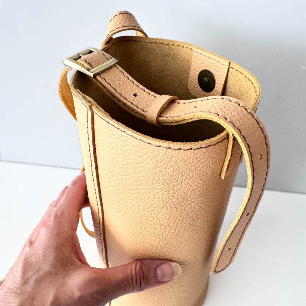 Helle kleine Ledertasche in beige sand Umhängetasche und Schultertasche. Mini Bucket bag mit rundem Boden. Längenverstellbarer Riemen. Magnetverschluss. Tasche handgefertigt aus genarbtem, glatten Rindleder. Auch in schwarz, braun, rot, weiß, grün usw. zu kaufen.