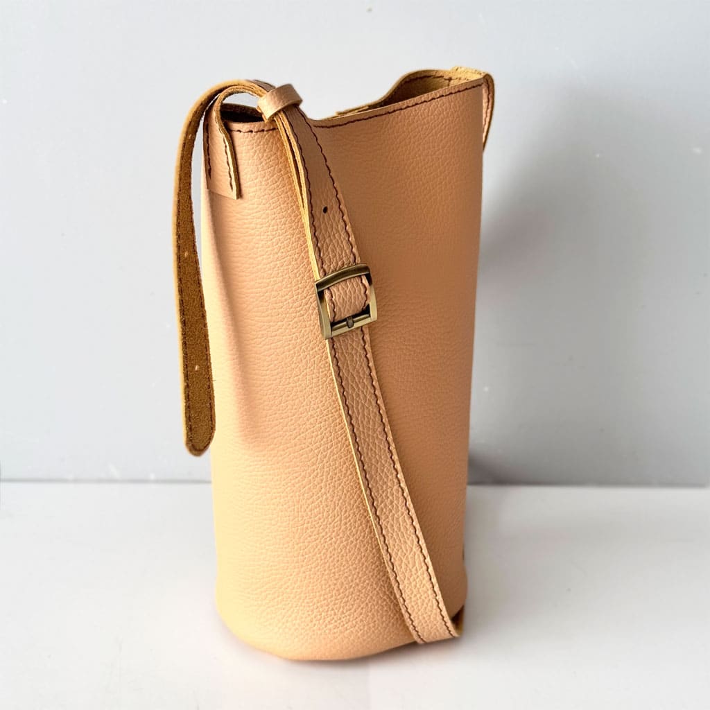 Helle kleine Ledertasche in beige sand Umhängetasche und Schultertasche. Mini Bucket bag mit rundem Boden. Längenverstellbarer Riemen. Magnetverschluss. Tasche handgefertigt aus genarbtem, glatten Rindleder. Auch in schwarz, braun, rot, weiß, grün usw. zu kaufen.